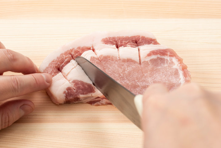 包丁の刃先を使って肉の表面に細かく浅い切れ目(筋切り)を入れる時短テクニック