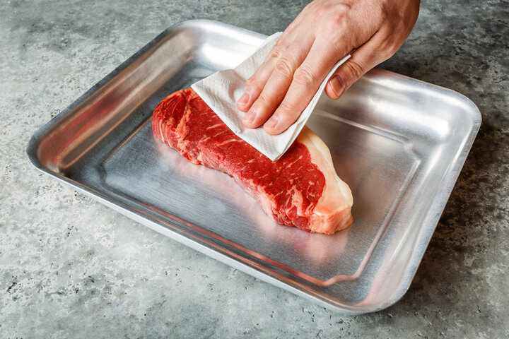 焼く直前にペーパータオルで肉の表面の余分な水分を丁寧に拭き取るプロの工程